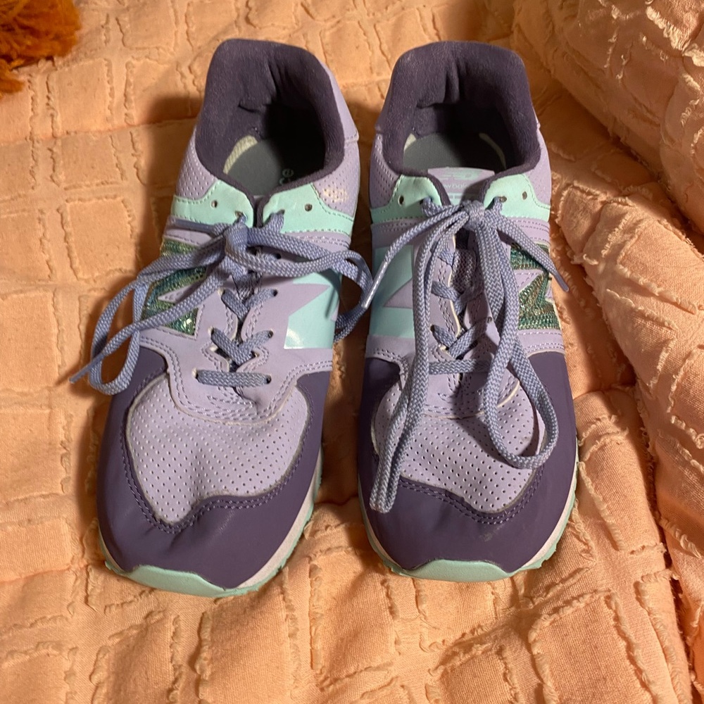 A pair of size 4.5 purple and mint new balance tennis shoes. In good condition.